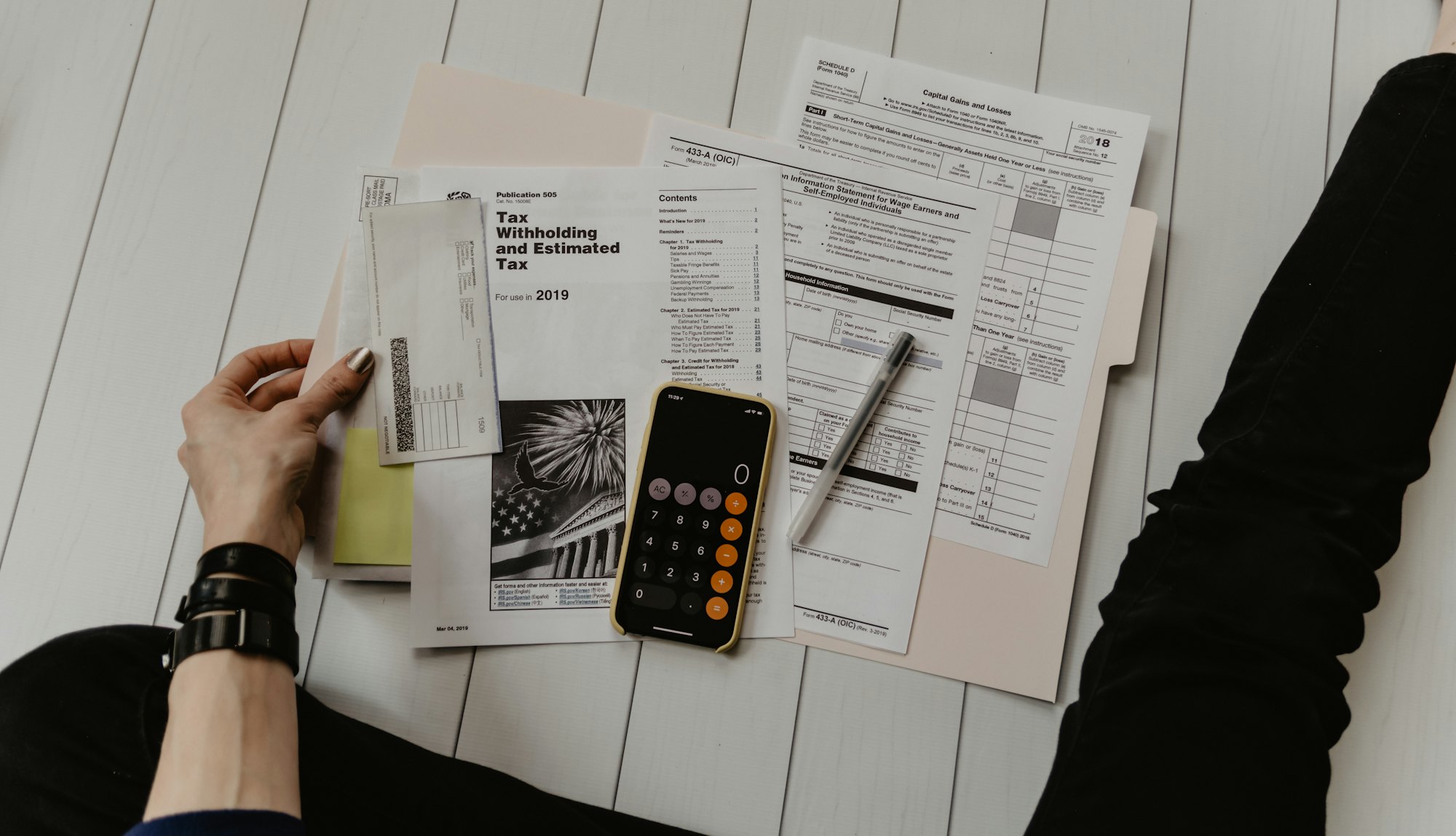 Deal paperwork, numbers and a calculator on a desk